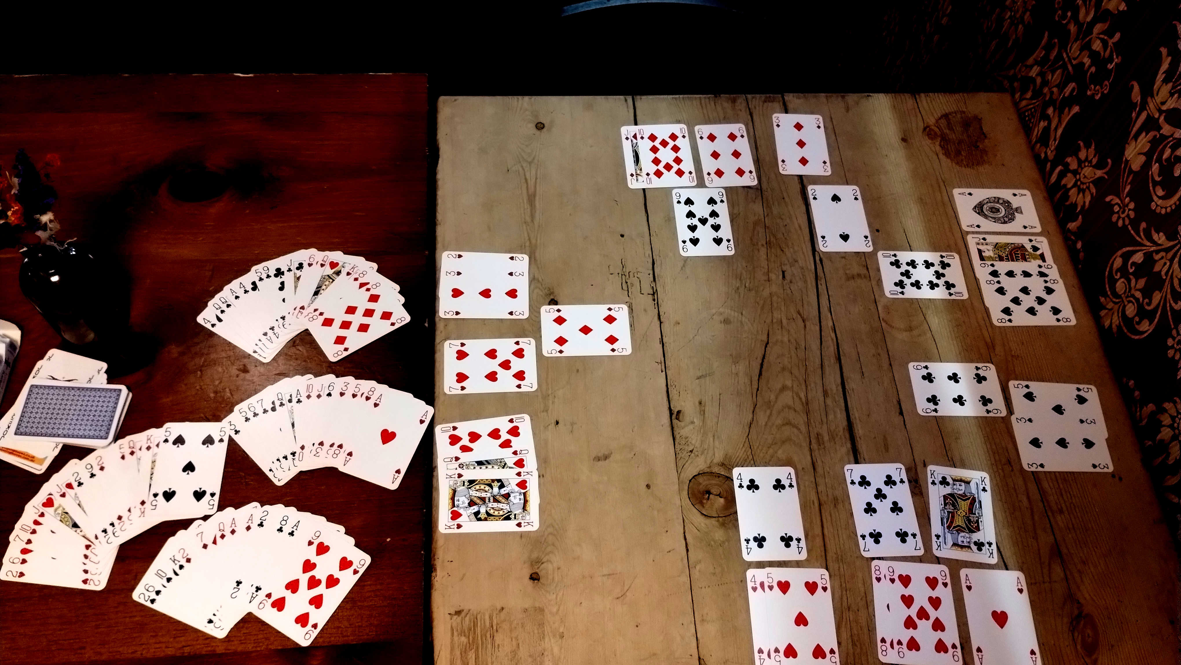 A mock-up of a game of Auction Calypso in progress. Both sides have Calypsoes in-progress in all suits.
                To the side of the layout is a set of hands dealt.